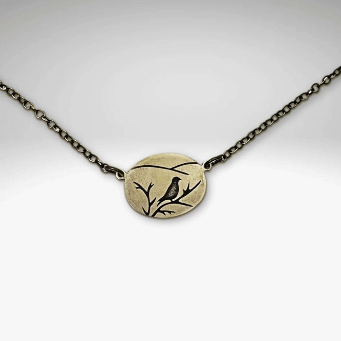 Mountain Bluebird Necklace featuring a delicate bluebird design on a small oval pendant with chain.