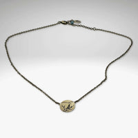 Mountain Bluebird Necklace featuring a delicate bluebird and mountain on an oval pendant, adjustable from 16-18 inches.
