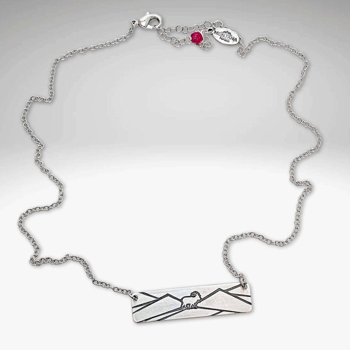 Mountain Goat Necklace on an adjustable silver chain, featuring mountain and goat design, perfect for nature enthusiasts.