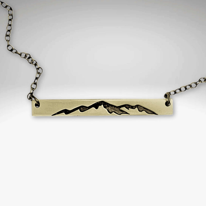Mountainscape Necklace featuring a raw brass bar etched with a mountain silhouette, adjustable from 16" to 18".