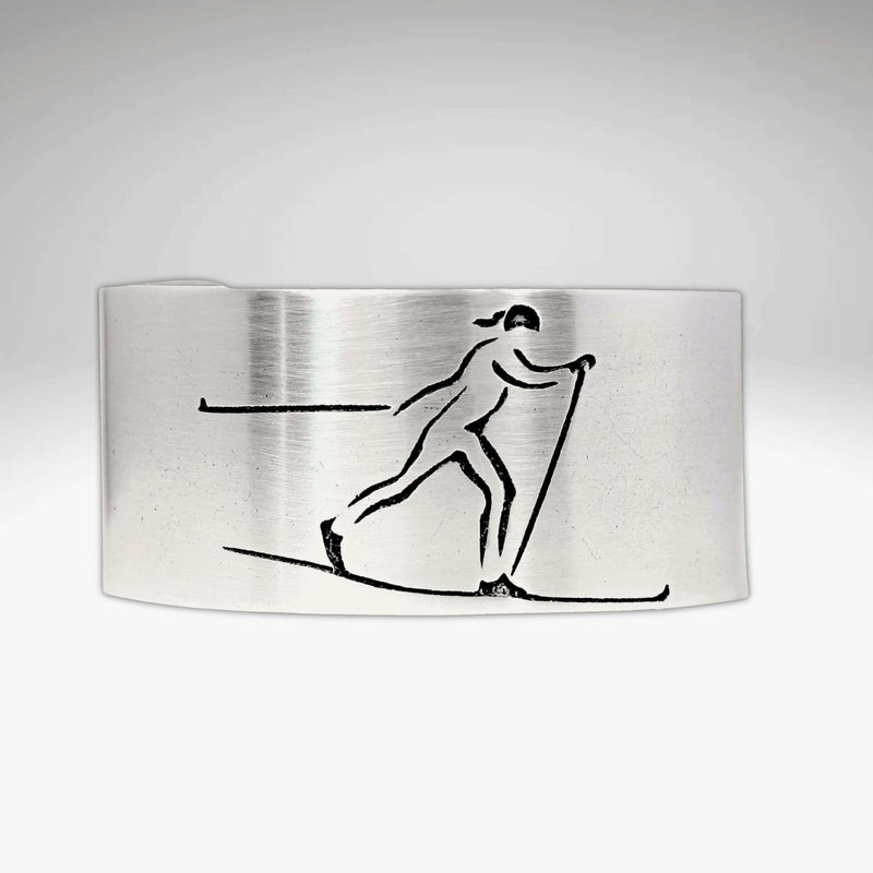 Nordic Run Cuff Bracelet with an etched image of a Nordic skier skiing in snow, perfect for outdoor adventure lovers.