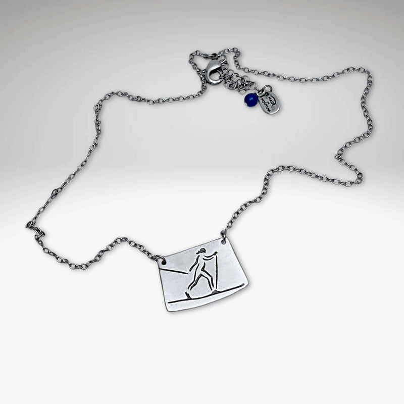 Nordic Run Necklace featuring a skier design on a silver chain, perfect for winter sports enthusiasts.