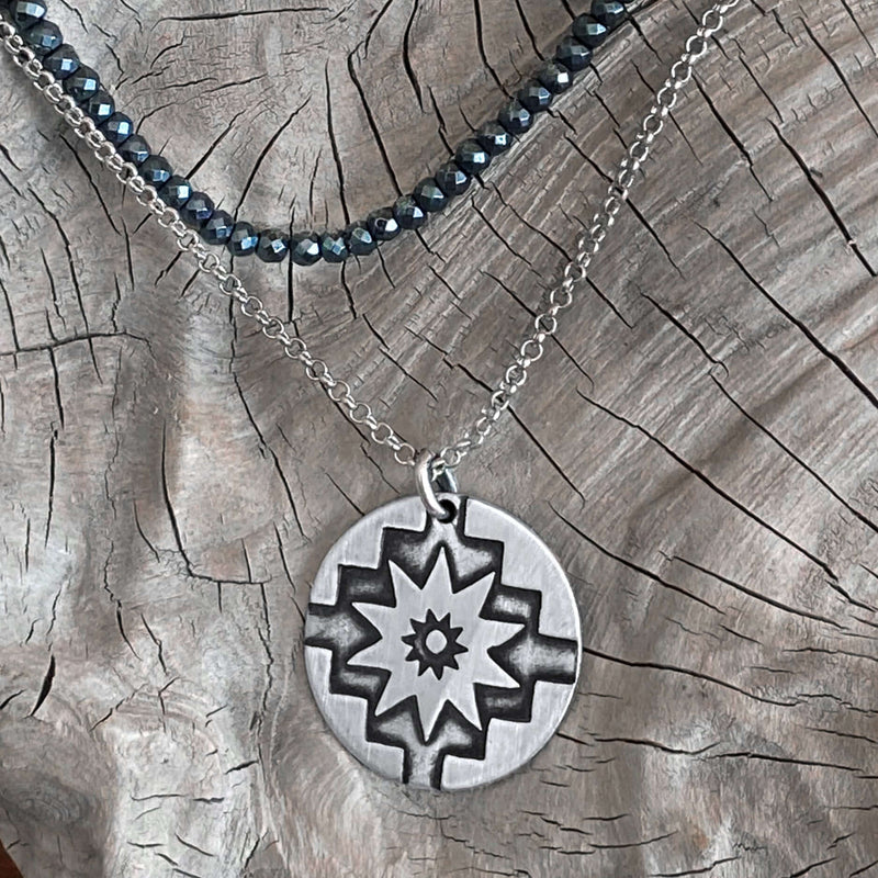 Northstar Necklace featuring a silver disk pendant on an adjustable chain, symbolizing courage and optimism.