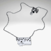 On the Front in Montana Necklace featuring an etched grain elevator and mountains on raw brass with an adjustable chain.