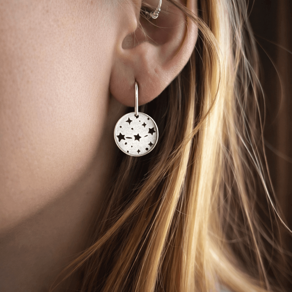 Orion's Belt Earrings worn by a model, showcasing the minimalist star design and subtle shimmer.