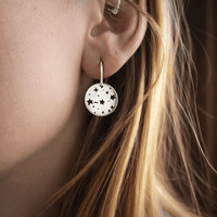 Orion's Belt Earrings worn by a model, showcasing the minimalist star design and subtle shimmer.