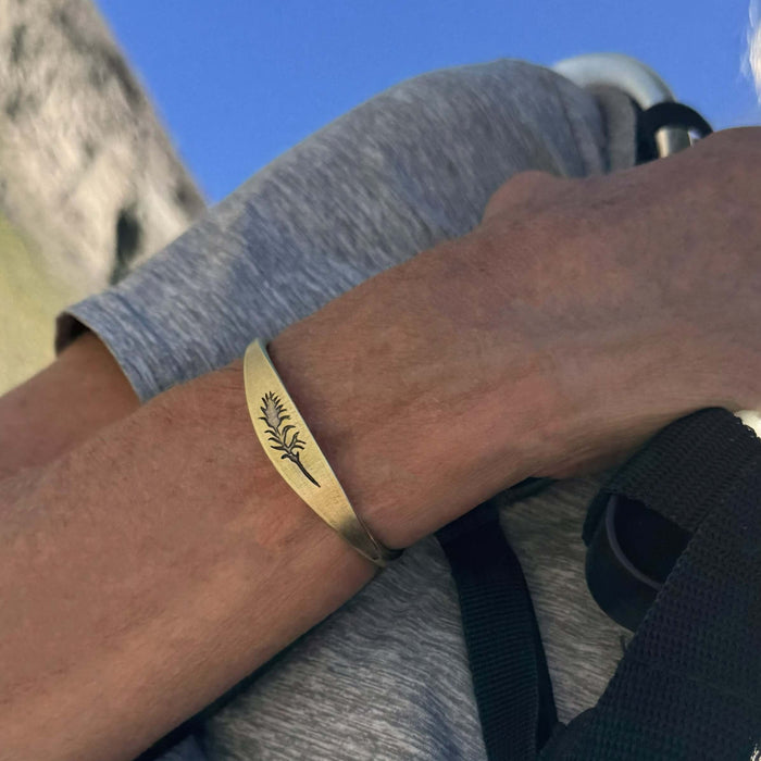 Paintbrush Signet Cuff worn on a wrist, featuring an elegant design in antique brass finish.