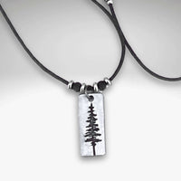 Elegant Pine Tree Necklace with a silver pendant on a leather cord, perfect for nature lovers.