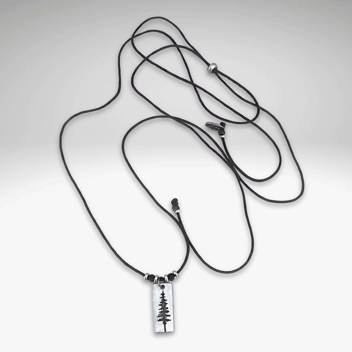 Pine Tree Necklace on a black cord, featuring a Ponderosa Pine Tree pendant design.