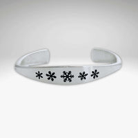 Powder Signet Cuff Bracelet featuring snowflake designs on a handmade adjustable cuff.