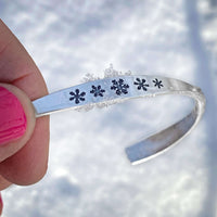 Close-up of the Powder Signet Cuff Bracelet featuring snowflake designs, perfect for winter lovers.