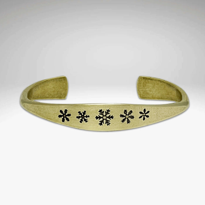 Powder Signet Cuff Bracelet with five snowflakes design, perfect for wintertime outdoor adventures.