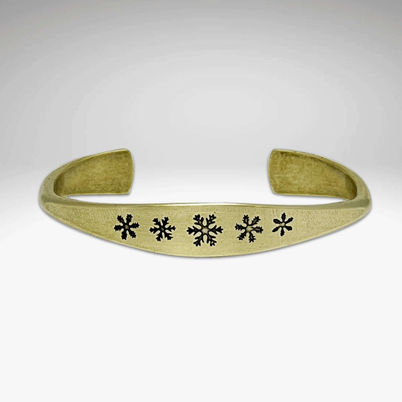 Powder Signet Cuff Bracelet with five snowflakes design, perfect for wintertime outdoor adventures.