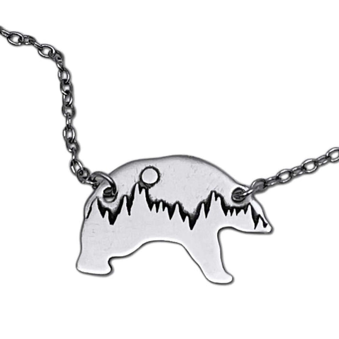Poya Bear Necklace featuring etched bear silhouette with mountains and sun, crafted in raw brass and adjustable chain.