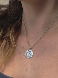 Close-up of the Bee in the Flowers Necklace featuring a circular pendant with wildflowers and a bee.
