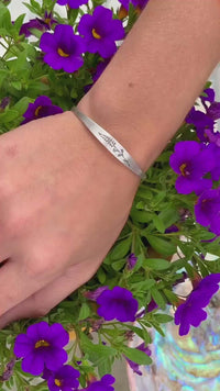 Lupine Flower Cuff Bracelet worn on a wrist surrounded by vibrant purple flowers.