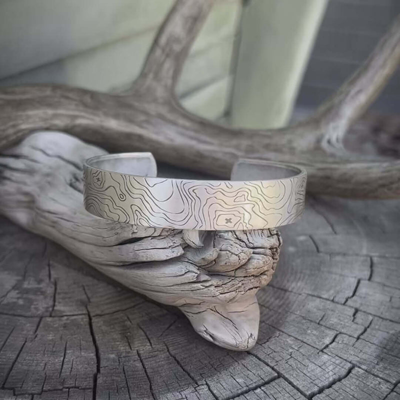 Topo Cuff Bracelet featuring intricate design on a rustic wooden surface.