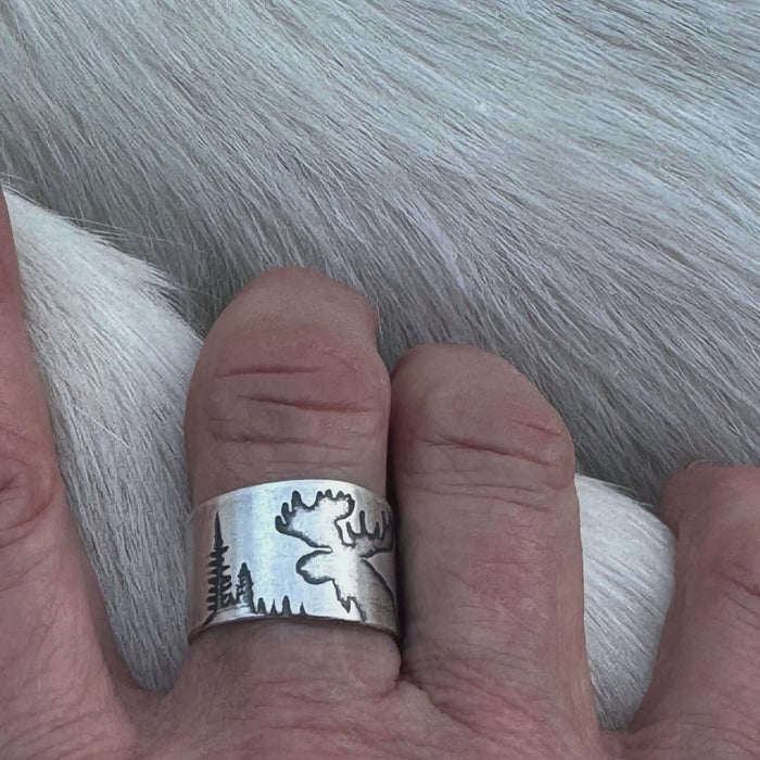 Creek Moose Adjustable Ring in matte silver  showcasing a moose silhouette against a forest backdrop.