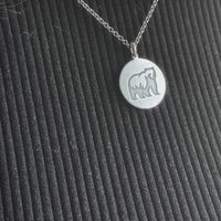 Grizzly Bear Pendant showcased on a necklace, featuring a simple design of a grizzly bear in silver.