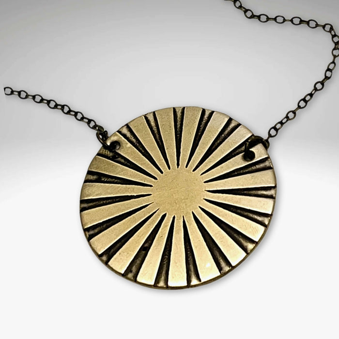 Ray Necklace featuring a sunburst pendant in Antique Brass finish on a delicate chain.
