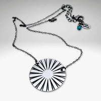 Ray Necklace with sun ray design in silver, showcasing a lightweight chain and unique disk pattern.