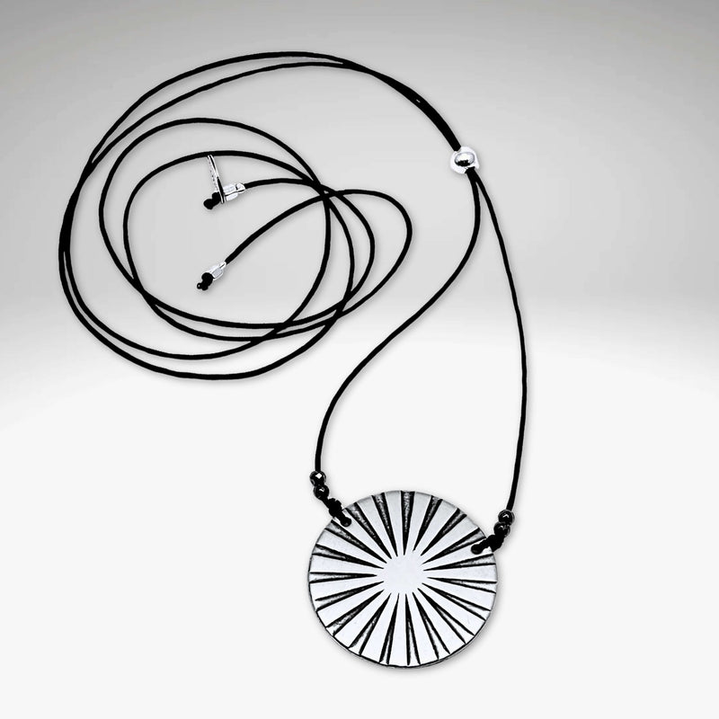 Ray Necklace on a black cord, featuring a unique sun ray design with a luminous effect.