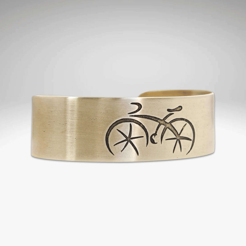 Ride Bicycle Cuff Bracelet featuring an etched bicycle design on raw brass.