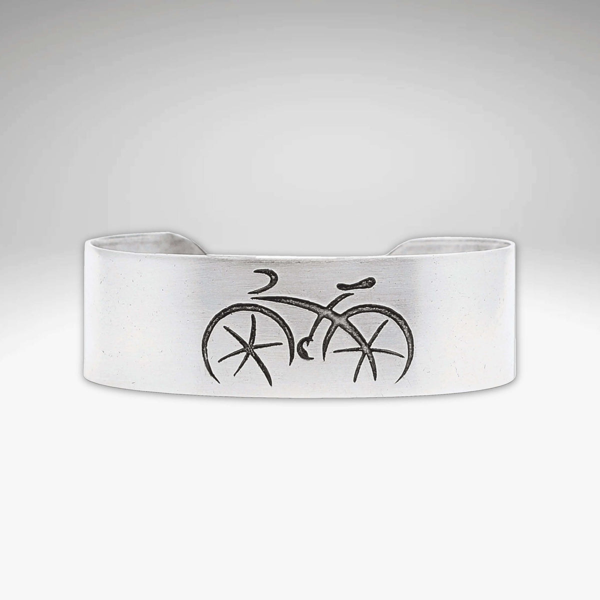 Ride Bicycle Cuff Bracelet featuring a simple bicycle design etched on raw brass.