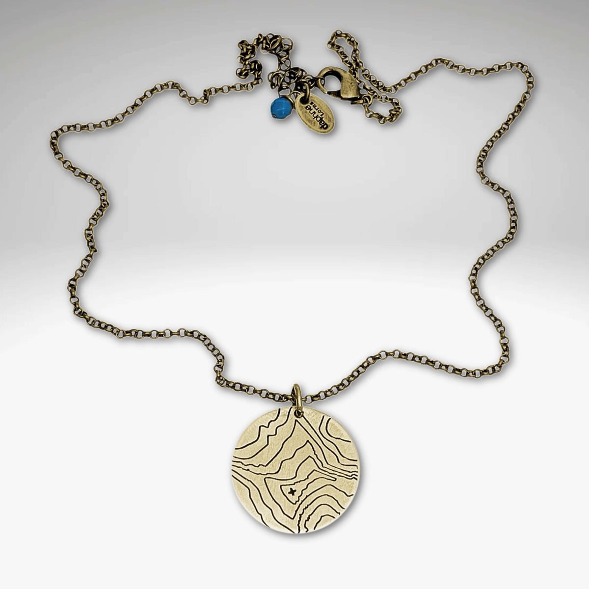 Rising Wolf Necklace featuring a detailed topographic map design in Antique Brass finish, perfect for nature lovers.