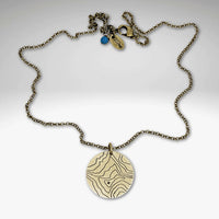 Rising Wolf Necklace featuring a detailed topographic map design in Antique Brass finish, perfect for nature lovers.