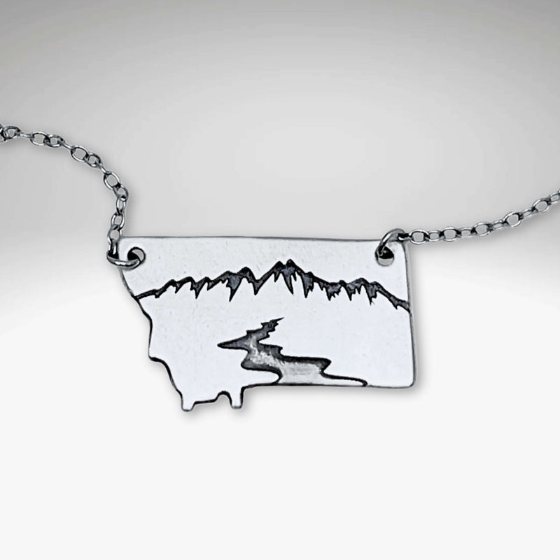 River Run Necklace showcasing a sleek Montana outline with mountains and a winding river design.