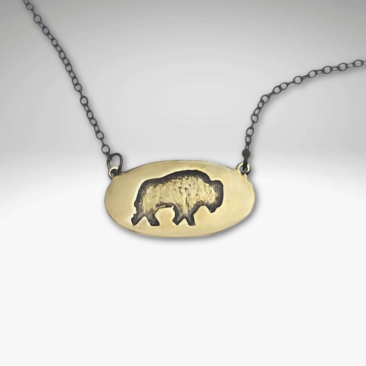 Roam Free Necklace featuring a buffalo design in Antique Brass and a delicate chain, perfect for nature lovers.