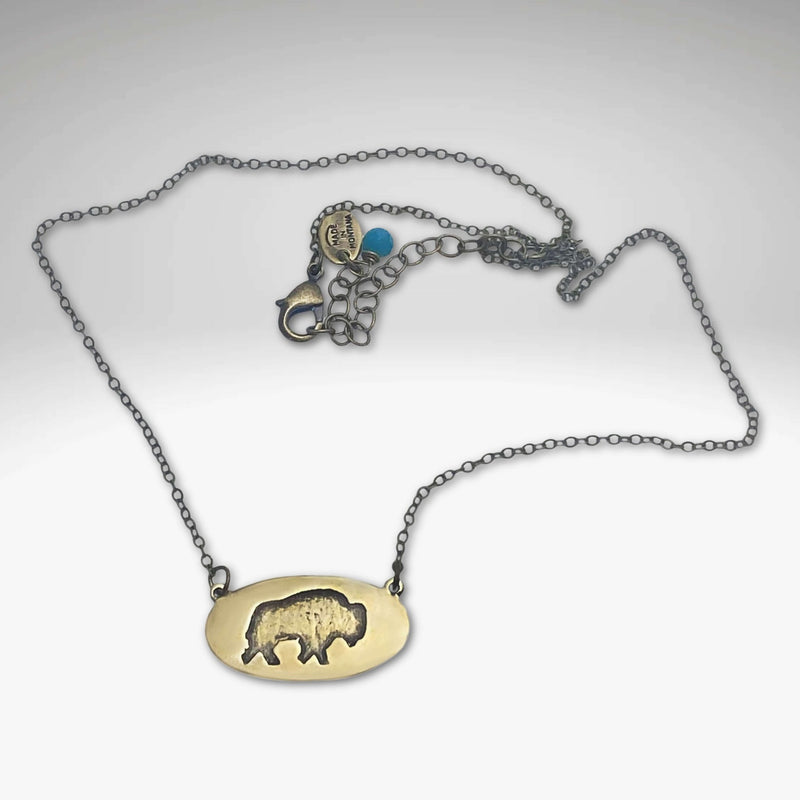 Roam Free Necklace featuring a buffalo design in antique brass on a delicate chain, perfect for nature lovers.