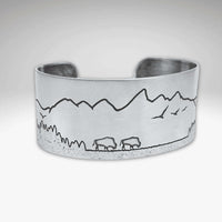 Roaming Buff on the Range Cuff Bracelet showcasing nature-inspired design with bison and mountain scenery.