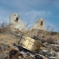 Roaming Buff on the Range Cuff Bracelet displayed outdoors with nature background and wildlife.