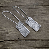 Rubble Rectangles Earrings made of hand-hammered brass with a matte silver finish, featuring kidney style earwires.