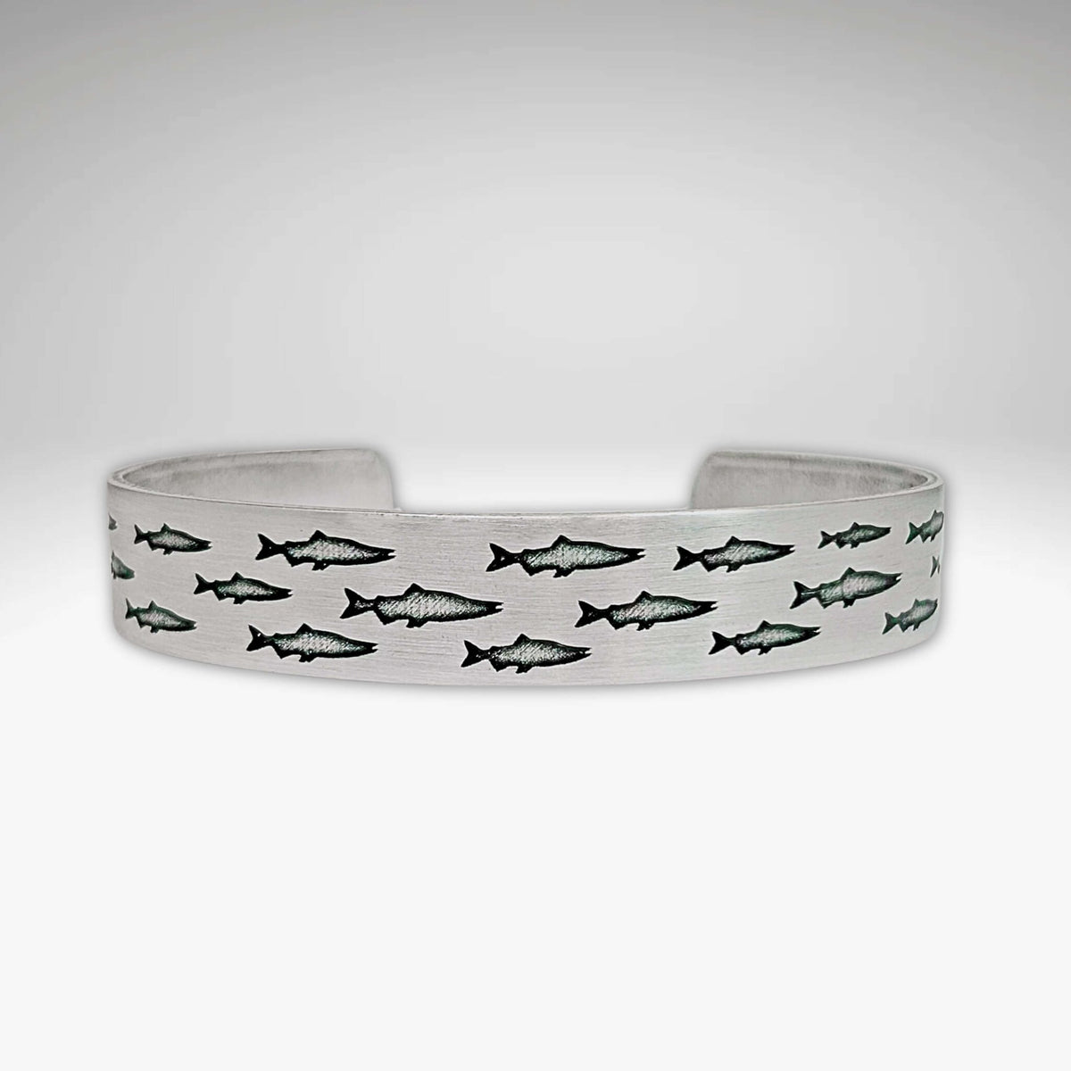 Salmon Run Cuff Bracelet featuring an intricate design of swimming salmon.