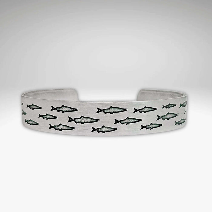 Salmon Run Cuff Bracelet featuring an intricate design of swimming salmon.