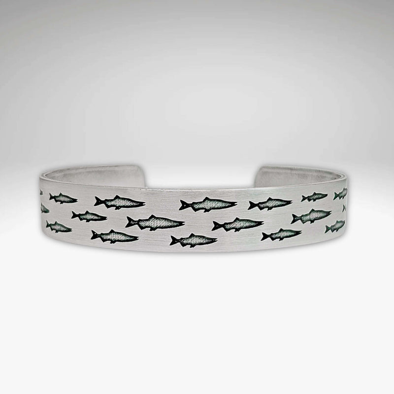 Salmon Run Cuff Bracelet featuring an intricate design of swimming salmon.
