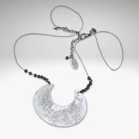 Scoop Necklace featuring a large geometric pendant on a silk cord with hematite beads, adjustable length from 16" to 18".