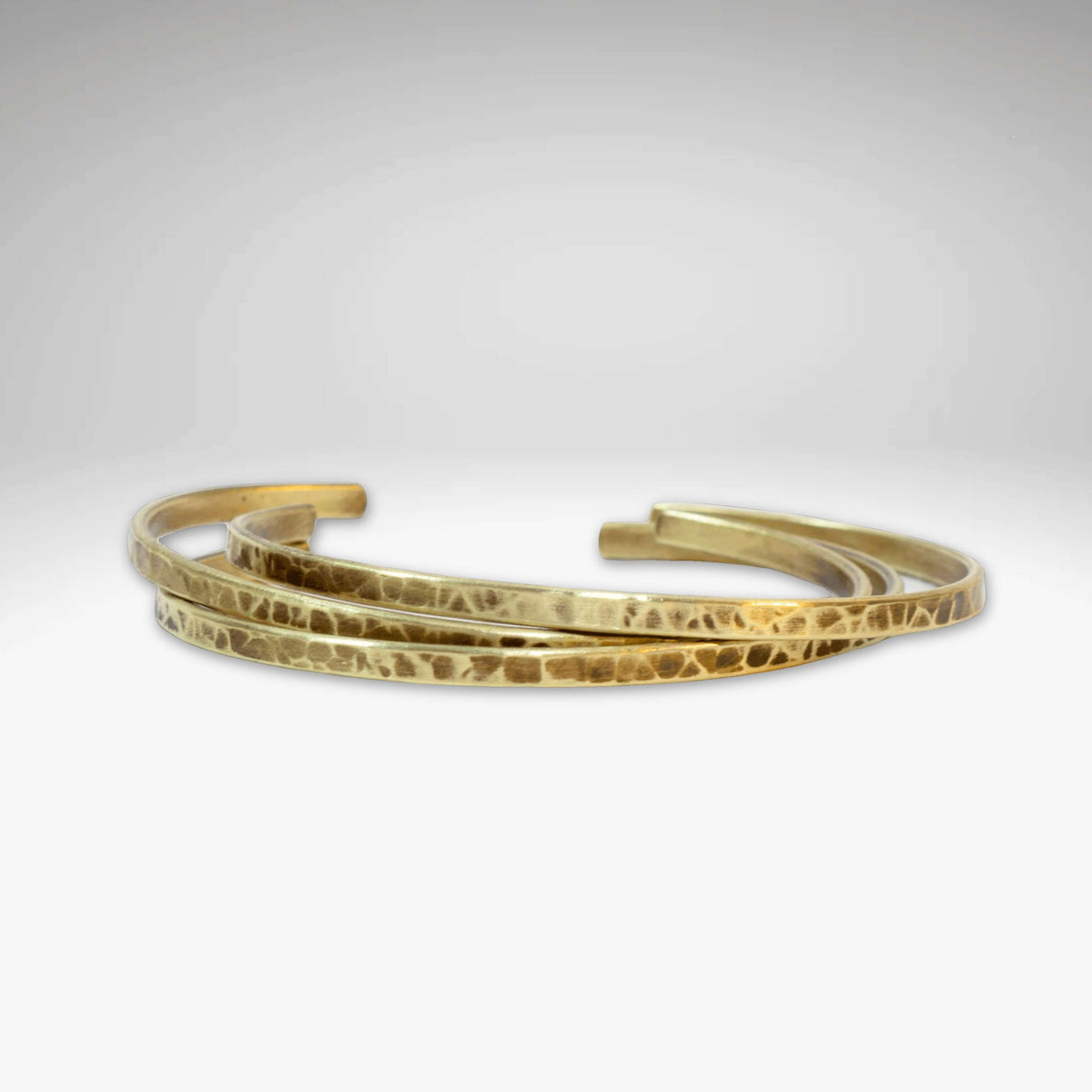 Set of Three Thin Cuff Bracelets featuring textured, hammered solid brass in a luxurious finish.
