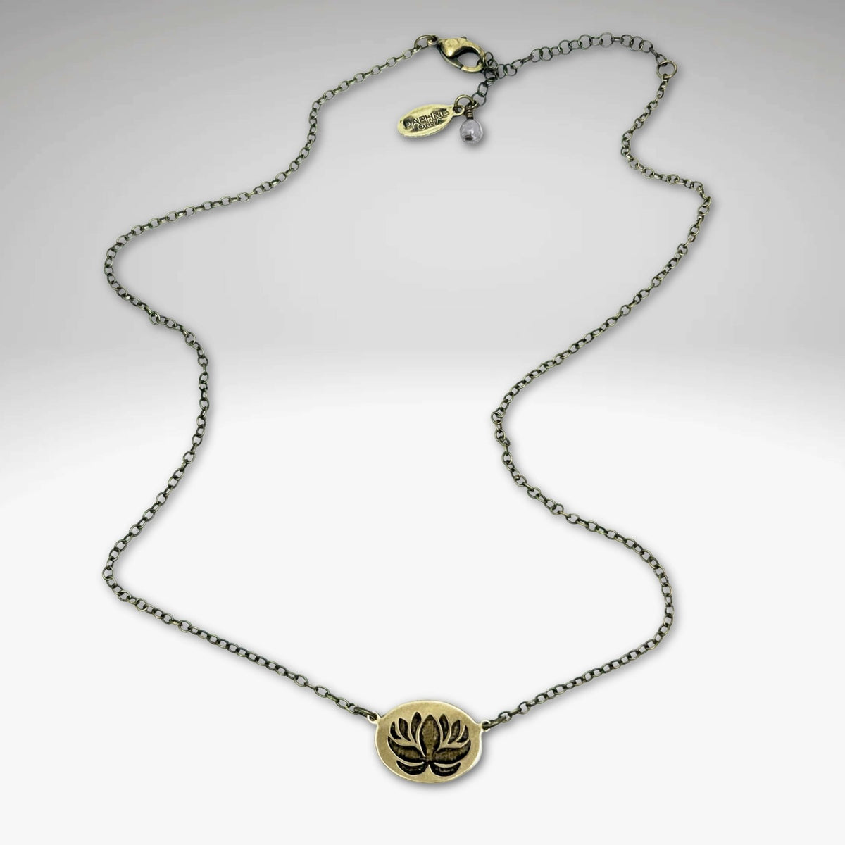 Simple Lotus Necklace featuring a small raw brass lotus pendant on a delicate chain.