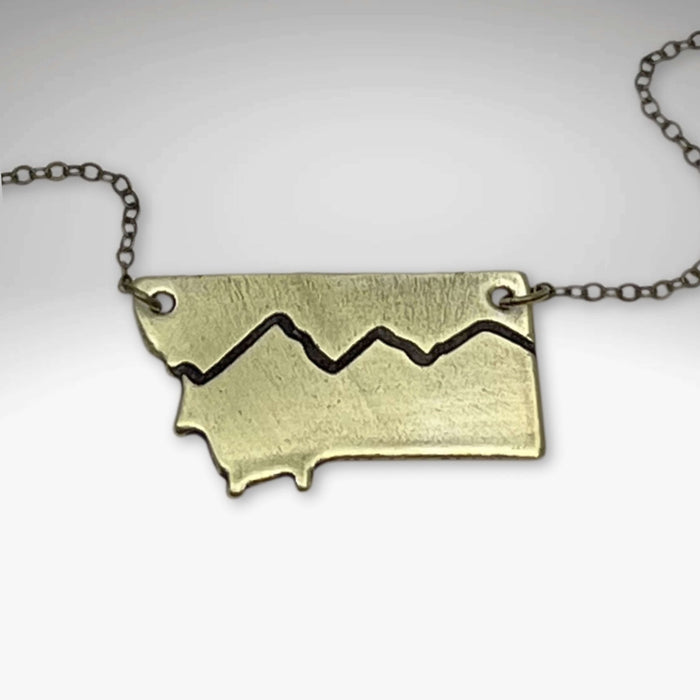 Simple Montana Necklace featuring a Montana-shaped pendant in antique brass on a chain.
