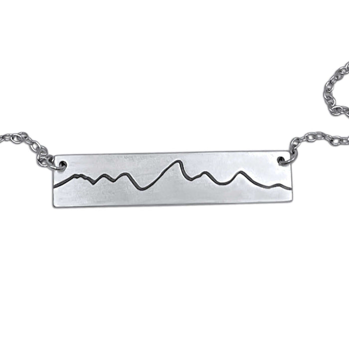 Simple Teton Mountain Necklace featuring a brass pendant with Teton mountain range outline.