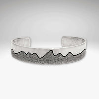 Simple Tetons Cuff Bracelet showcasing a unique mountain design and deep etching process, perfect accessory for nature lovers.