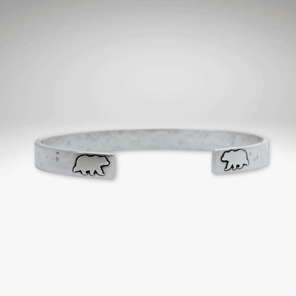 Skinny Bear Cuff Bracelet featuring bear engravings, 1/4" wide with a unique hammered texture.
