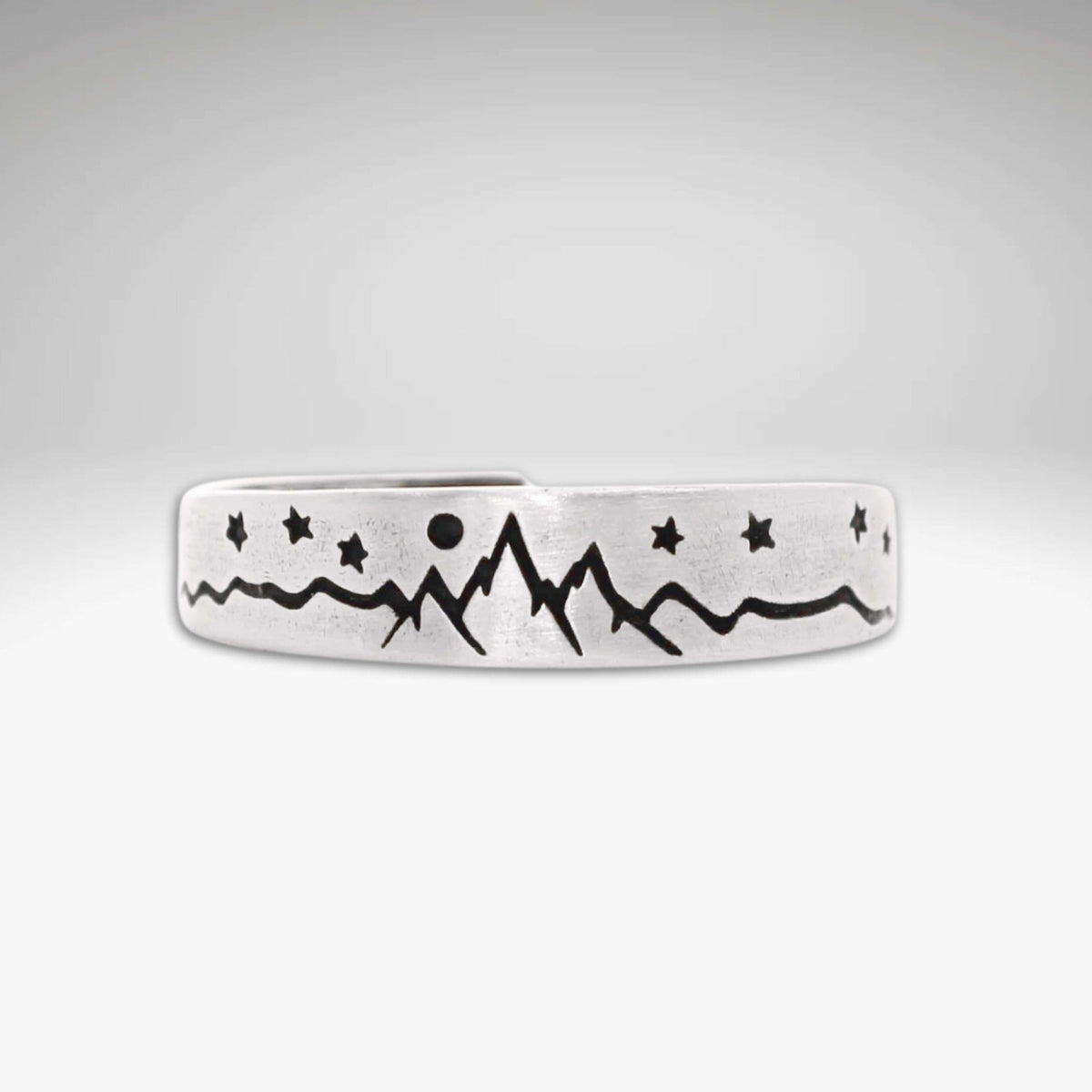 Skinny High Alpine Adjustable Ring with mountain and star design on a raw brass band.