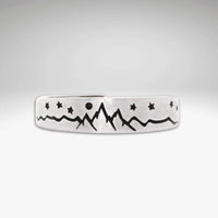 Skinny High Alpine Adjustable Ring with mountain and star design on a raw brass band.