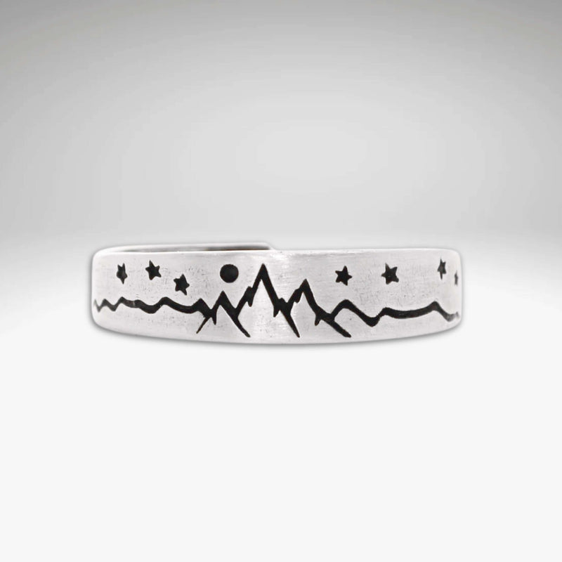 Skinny High Alpine Adjustable Ring with mountain and star design on a raw brass band.