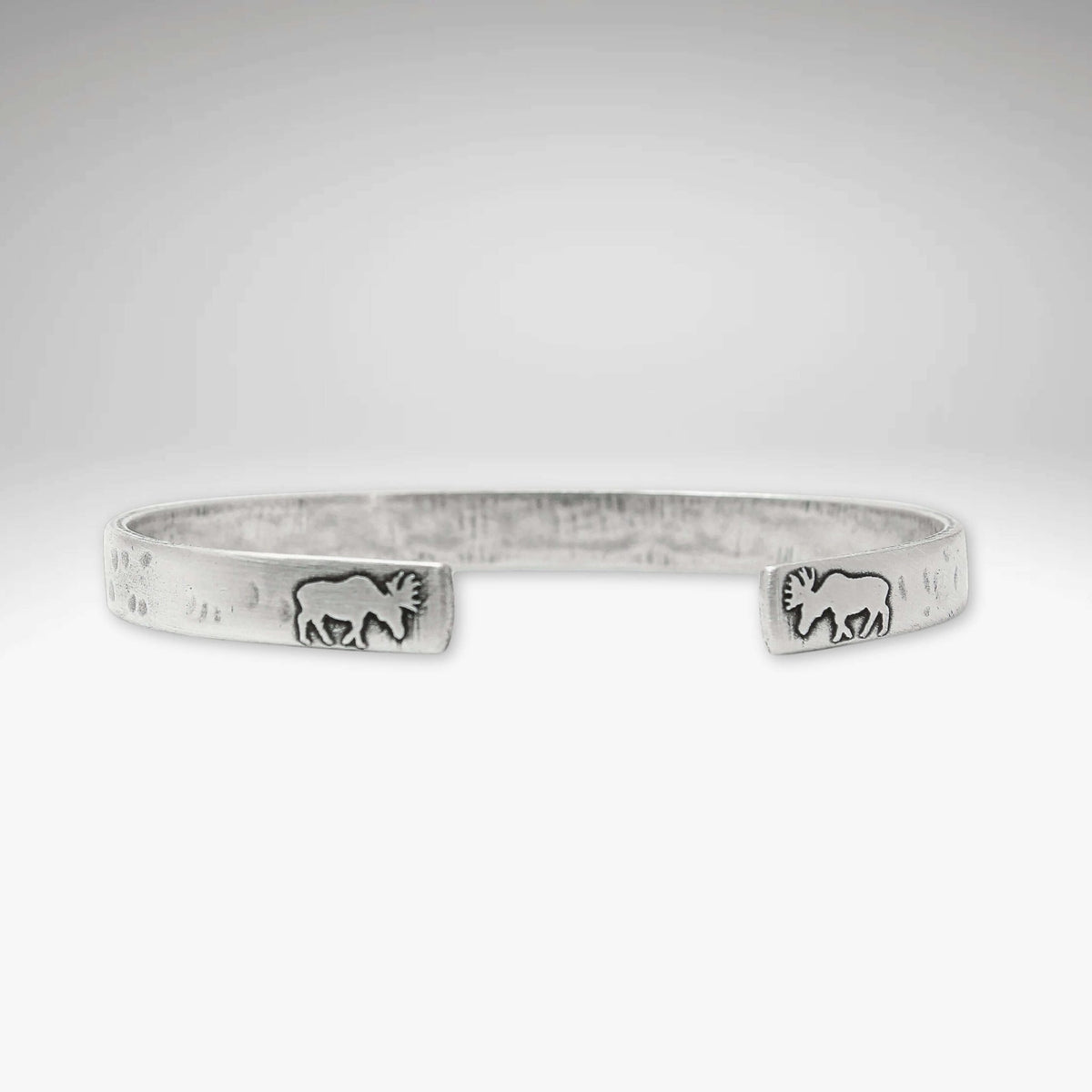 Skinny Moose Cuff Bracelet featuring moose designs on tips, showcasing unique etching process and raw brass finish.